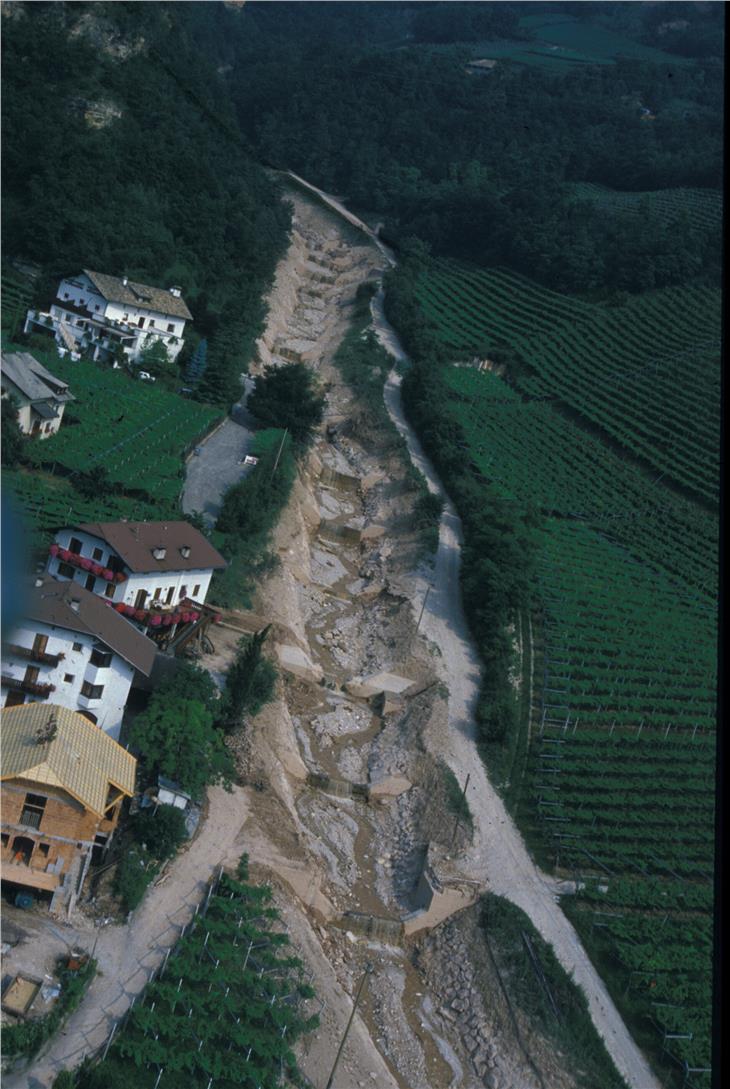 Im Laufe der Jahrhunderte wurde Tramin immer wieder von Unwetterereignissen getroffen, zuletzt 1986, als vom Höllentalbach ausgehend drei Murschübe das Dorf erreichten, wie das Archivbild zeigt. Foto: Agentur für Bevölkerungsschutz