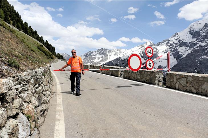 Hauptstraßenwärter Hubert Pfeifer öffnet die Schranke: Die Straße auf das Stilfser Joch ist jetzt wieder befahrbar (FOTO: LPA/Roman Clara)