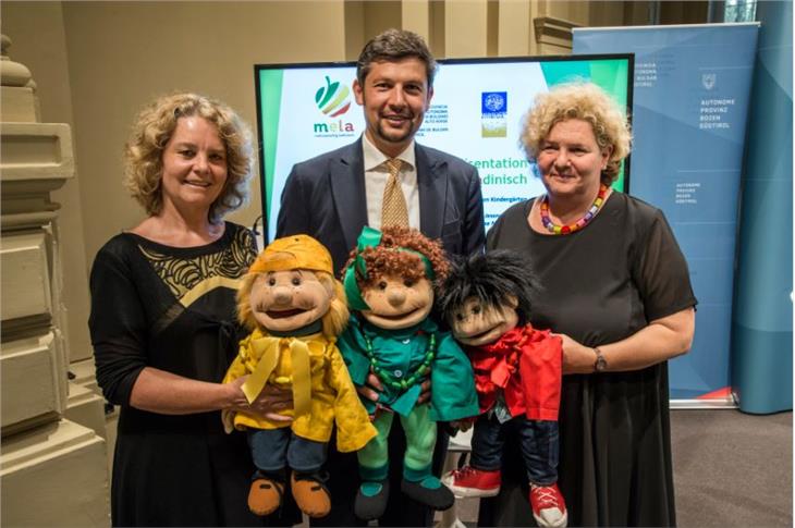 Ploner, LR Alfreider und Prof. Jessner-Schmid bei der Präsentation der Ergebnisse der Studie zur Mehrsprachigkeit mit den "Sprach-Puppen", die in den ladinsichen Kindergärten Kindern beim Lernen helfen (FOTO: LPA/Peter Daldos)