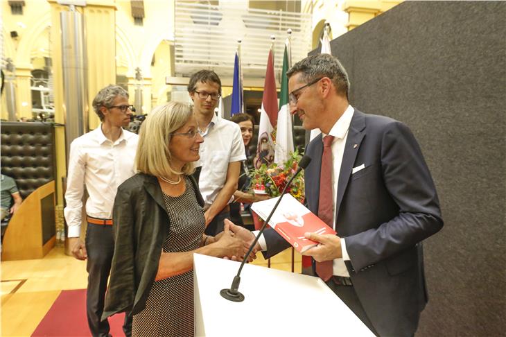 LH Kompatscher überreicht das Buch von Adolf Aukenthaler an Frau Frau Elisabeth und die Söhne Markus und Thomas (Hintergrund l. u r.). (Foto LPA/Oskar Verant)