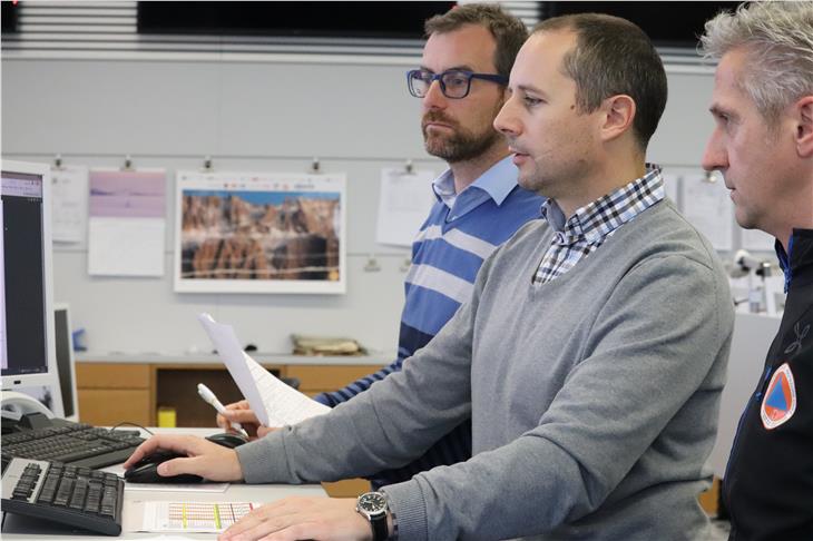 Situation im Blick (v.re.): Bewertungskonferenz-Vorsitzender Willigis Gallmetzer, Landeswetterdienst-Koordinator Günther Geier, Diensthabender Andreas Simmerle vom Bereitschaftsdienst des Zivilschutzes. (Foto: LPA/Maja Clara)