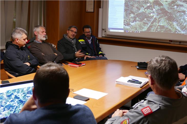 LH Kompatscher (hinten 2.v.r.) informiert sich in der Bezirksleitstelle Pustertal über die Arbeit der Einsatzkräfte. (Foto: LPA/Dominik Holzer)