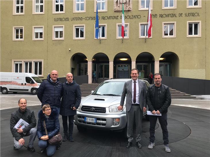 Hilfe nach dem Erdbeben noch immer nötig: LR Bessone und Bürgermeister Camillo D’Angelo (r. u. l.) vor dem Auto Mitarbeitern der Gemeinde Valle Castellana und der Landesabteilung Vermögen. (Foto: LPA)