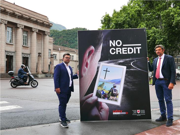 Der Leiter Verkehrssicherheitszentrum Safety Park Sebastian Seehauser  (l.) und LR Daniel Alfreider mit dem Großplakat der No-Credit-Kampagne, das an viel befahrenen Straßen angebracht wird. (Foto: LPA/Roman Clara)