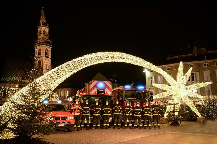 Alle Jahre wieder: Für ihre Weihnachtsgrüße hat sich eine Gruppe der Berufsfeuerwehr auf den Bozner Waltherplatz gestellt. Mit einem selber produzierten Video erklären sie Regeln zum Brandschutz. (Foto: AfBS/Berufsfeuerwehr)