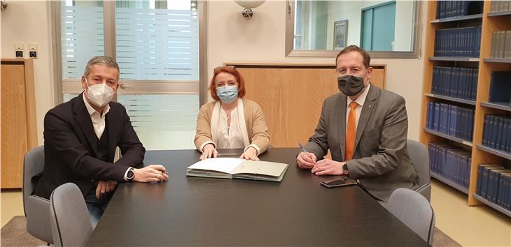 Bürgermeister Brunner (l.) und Landesrat Bessone (r.) setzten vor der stellvertretenden Landesanwältin Alexandra Roilo ihre Unterschrift unter die Vereinbarung zwischen Land und Gemeinde. (Foto: LPA/Anna Pitarelli)