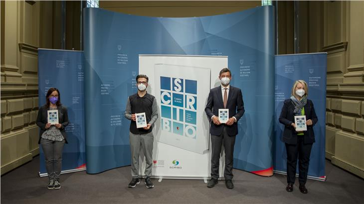 Projektleiterin Barbara Perathoner, Autor Bruno Maruca, LR Alfreider und die Direktorin des Ressort Ladinische Bildungs- und Kulturdirektion Ploner mit der neuen Kurzgeschichtensammlung "Scribo". (Foto: LPA/Fabio Brucculeri)