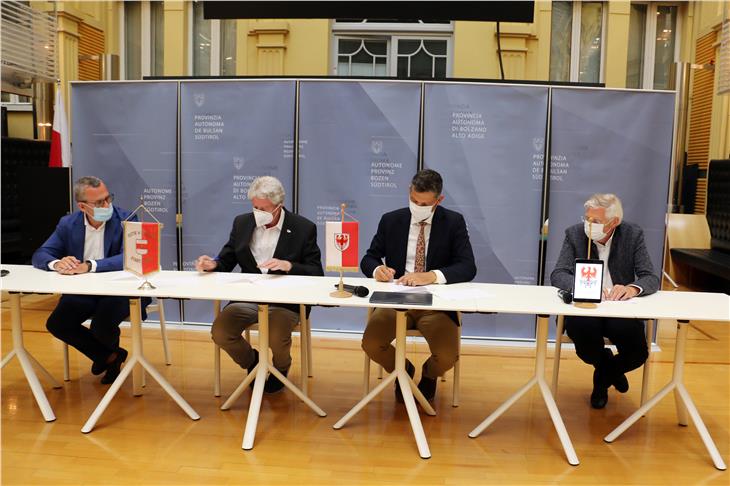 v.l.: Bianchi, Caramaschi, LR Alfreider und Berger unterzeichnen die gesellschaftliche Nebenvereinbarung, die den betroffenen Gemeinden Mitspracherecht sichert. (Foto: LPA/Ingo Dejaco)