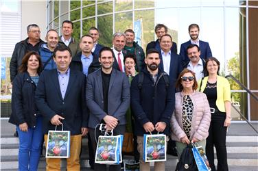 Gruppenbild mit Landesrat Schuler (Bildmitte) vor dem Haus des Apfels in Terlan: Zu den zwölf Vertretern griechischer Genossenschaften kam auch der stellvertretende Sprecher des Agrarausschusses der Nea Dimokratia dazu. Foto: LPA