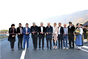 Vize-Landeshauptmann Christian Tommasini, Bürgermeister Roland Lazzeri und Landesrat FLorian Mussner mit Vertretern von der Gemeinde und dem Land beim Banddurchschneiden zur Eröffnung des neuen Straßenabschnitts (Foto: LPA/R. Clara)