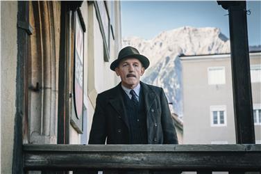 Der bekannte Schauspieler Karl Markovics in einer Szene des Kinofilm "Der Geldmacher" - im Hintergrund eine Südtiroler Bergspitze. Foto: IDM/ epo-film produktionsges.
