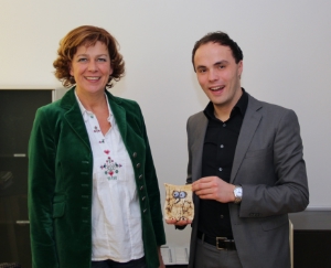 L'assessora uscente Sabina Kasslatter Mur consegna una civetta in terracotta al neo assessore Philipp Achammer, quale simbolo di saggezza- Foto: USP/ Martin Silbernagl