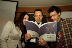 Camp for Company: l'assessore Christian Tommasini sfoglia il libro assieme a due dei ragazzi che hanno partecipato al progetto