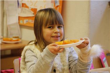 Un caco tagliato a fette è stato distribuito stamani ai bambini della scuola Dante di Bolzano Foto Usp Clara